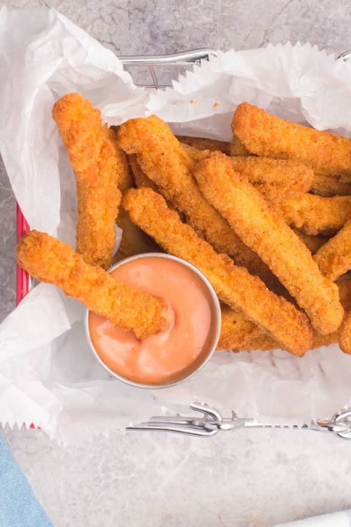 Chicken fry being dipped into sauce