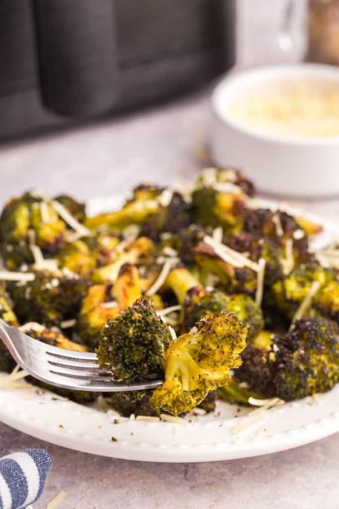 white plate full of broccoli cooked in air fryer