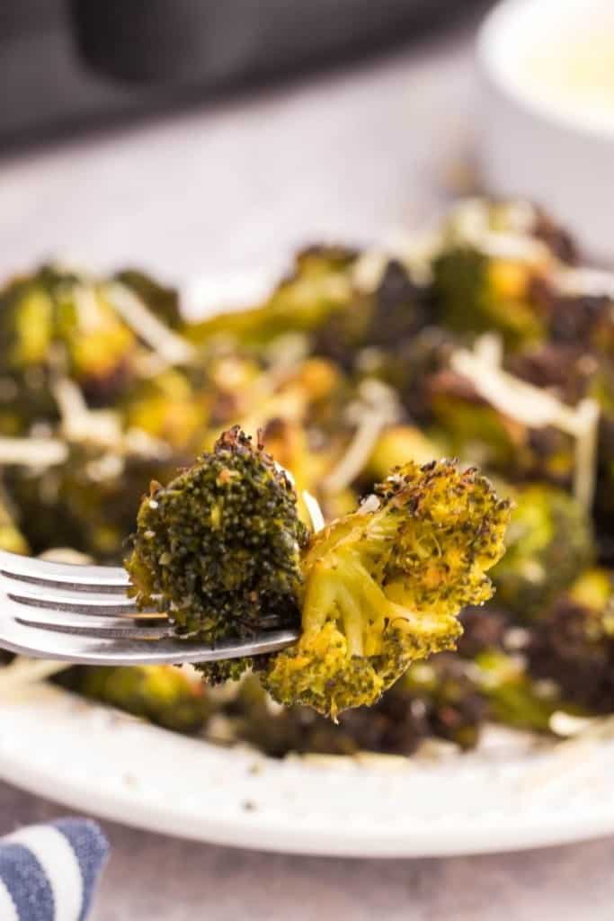 Close up of fork picking up piece of air fryer broccoli