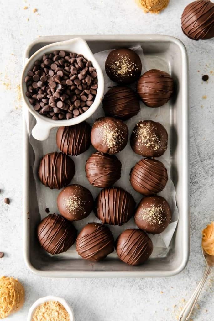 tray with peanut butter balls and extra chocolate chips in white cup