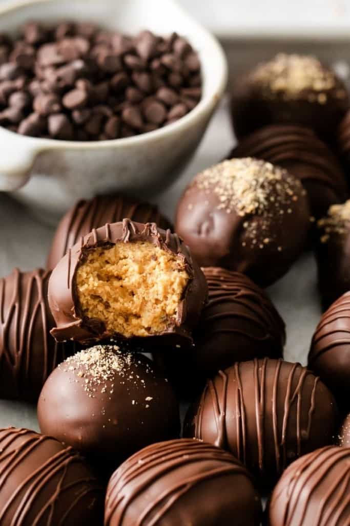 Pile of peanut butter balls and the top one has a bite taken out of it