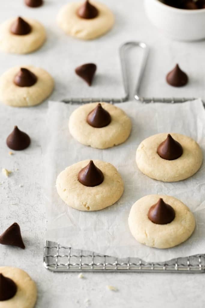 parchment paper with lots of sugar cookies with hershey kisses