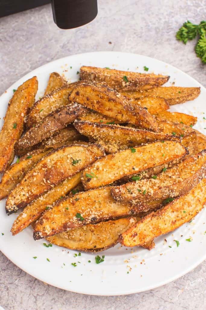 white plate with air fryer potato wedges ready to serve
