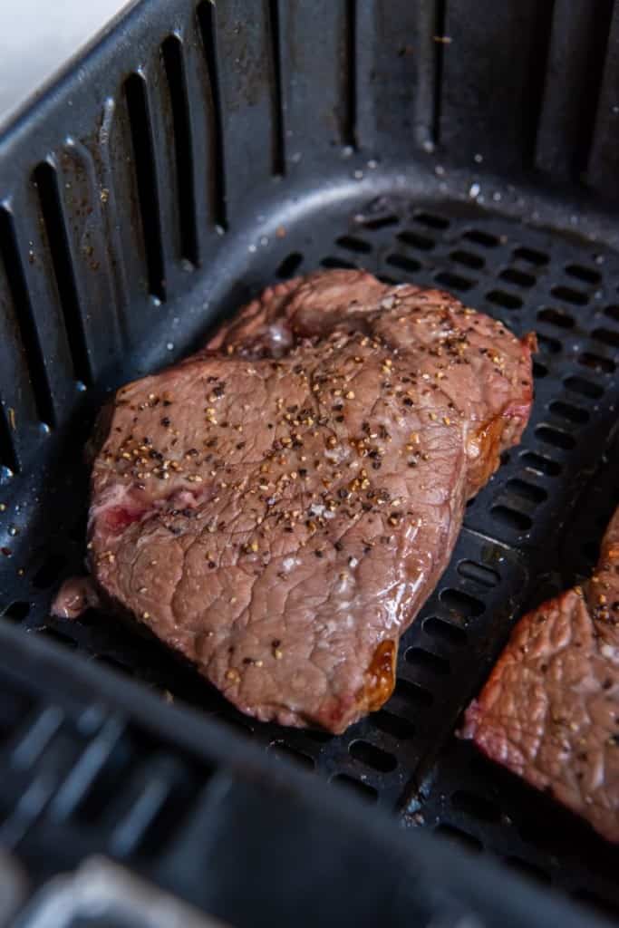 cooked sirloin steak in air fryer basket