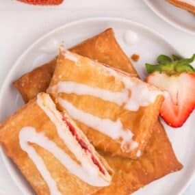 air fryer toaster strudel on white plate with a strawberry