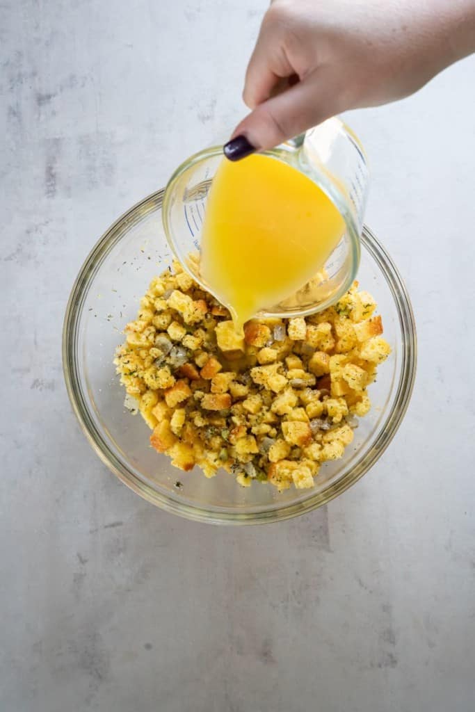 pouring broth into bowl with stuffing