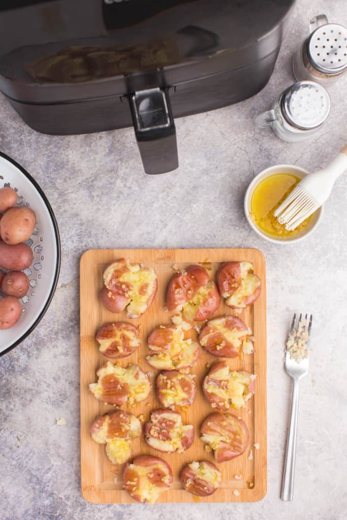 cutting board with smashed potatoes