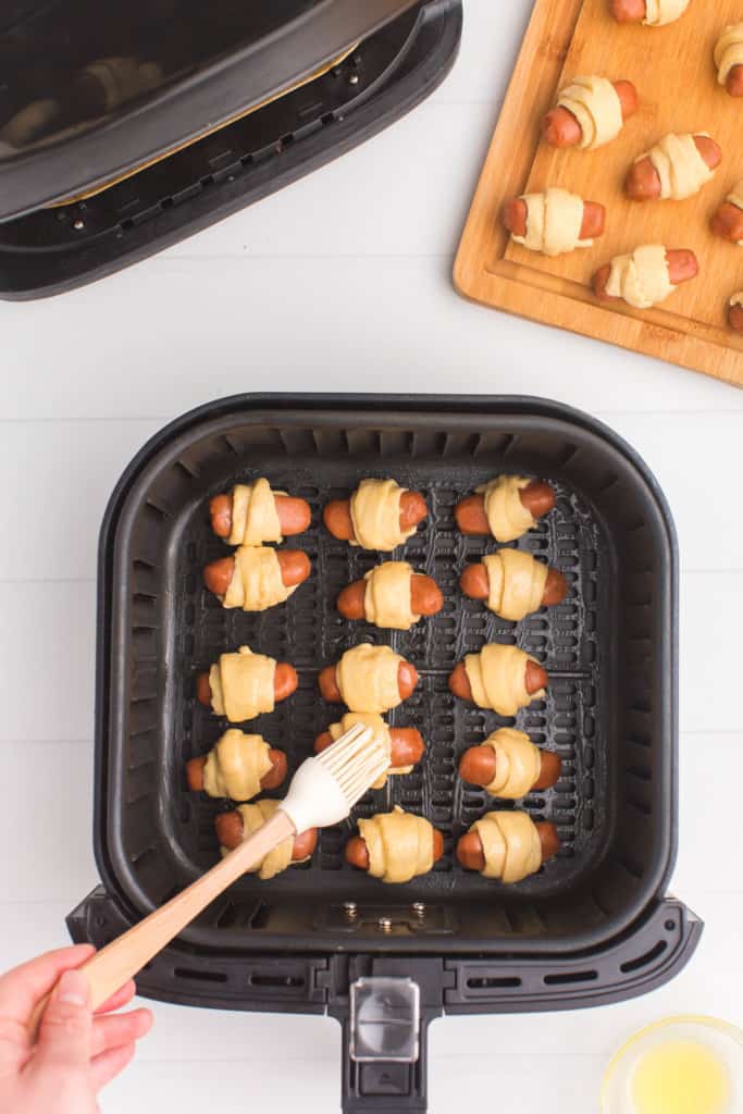 brushing pigs in blankets with melted butter