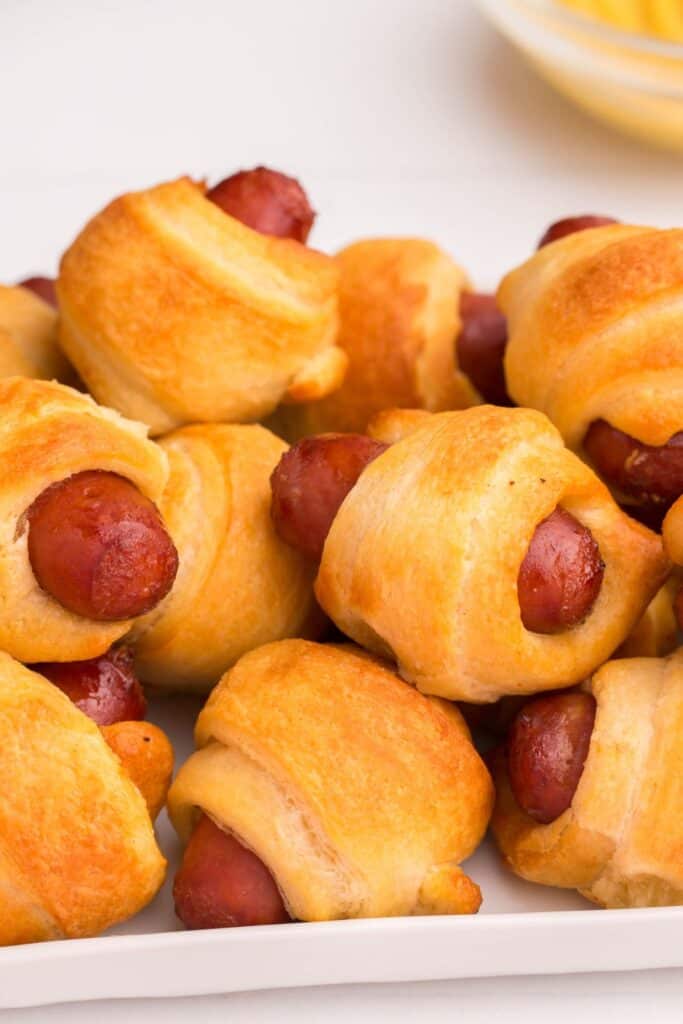 Close up of air fryer pigs in a blanket so you can see the golden brown of the crescent rolls.