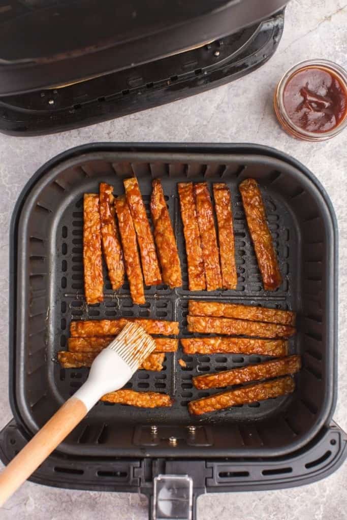 brushing tempeh with bbq sauce