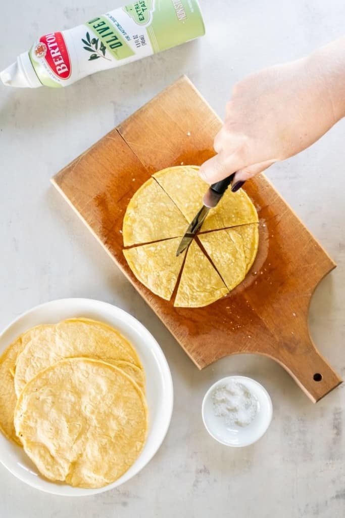 Corn tortillas being cut to be placed in the air fryer