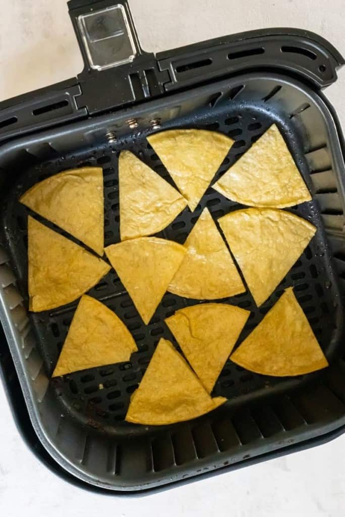 tortilla chips cooking in the air fryer basket