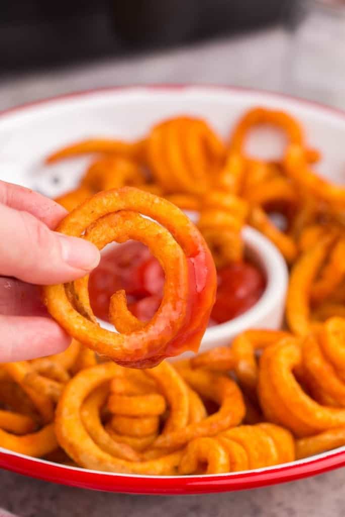 curly fry being dipped in sauce