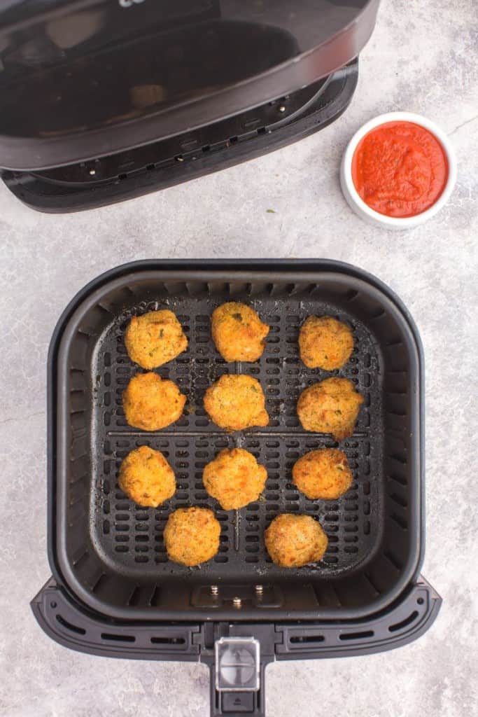 an air fryer basket with mac and cheese balls