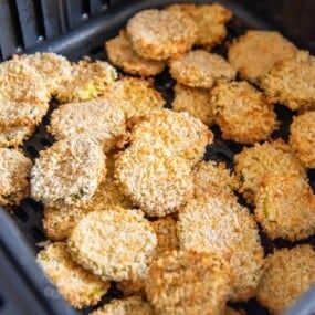 Fried pickles in an air fryer basket.