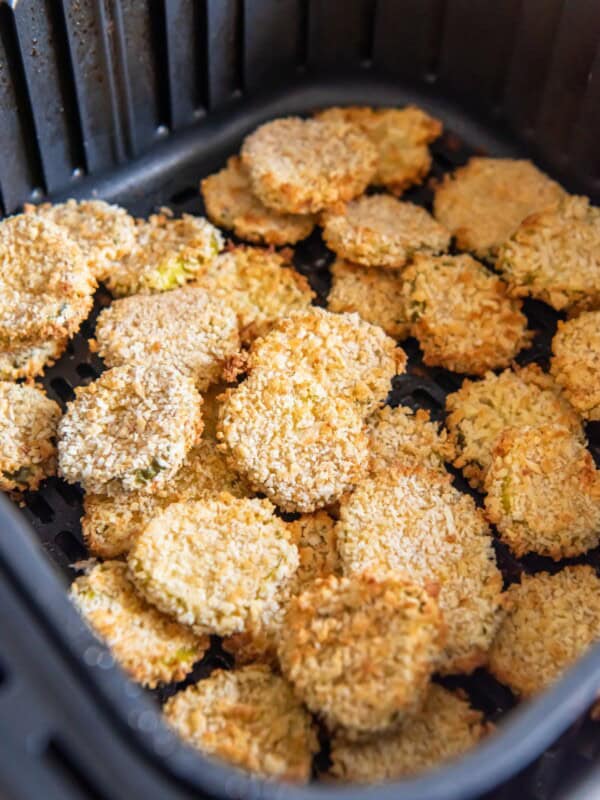 Fried pickles in an air fryer basket.