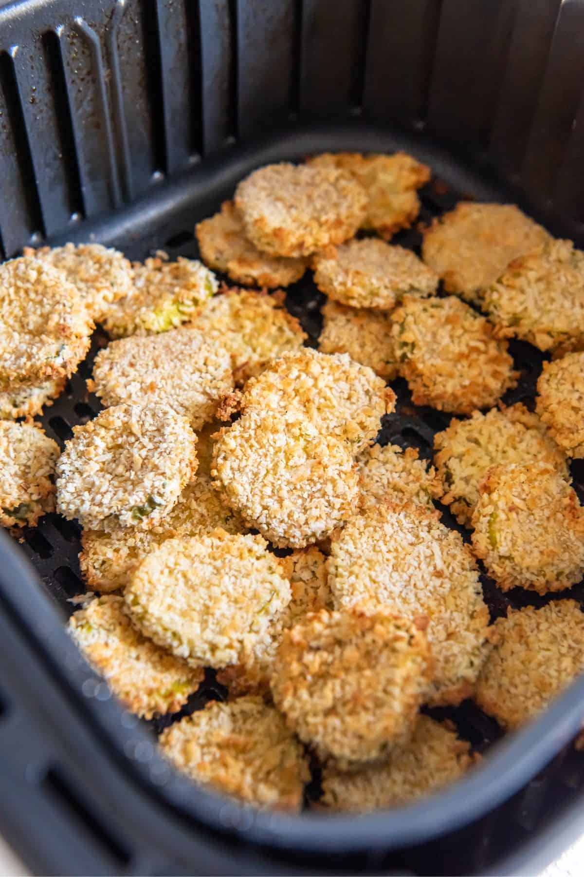 Fried pickles in an air fryer basket.