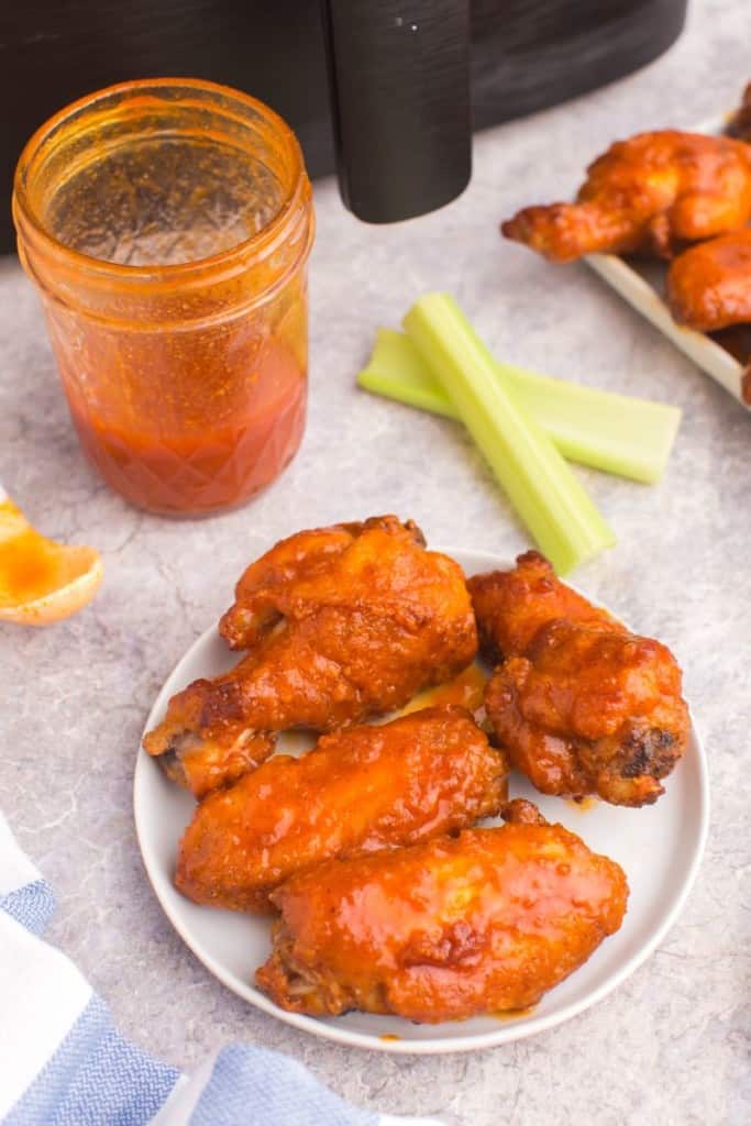 plate with chicken wings coated in honey buffalo sauce