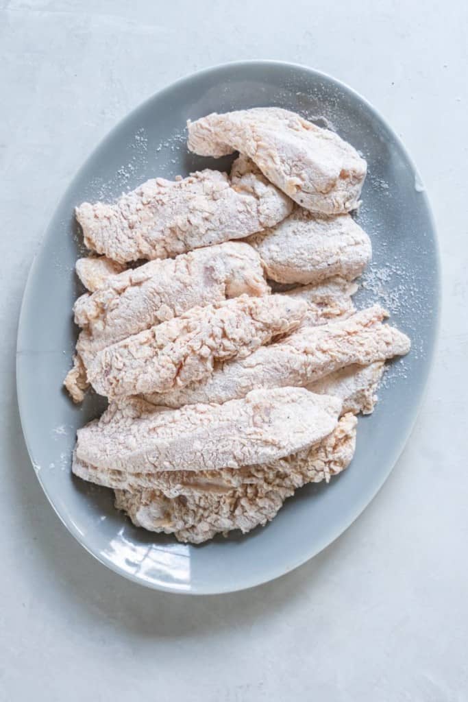 floured chicken strips on platter