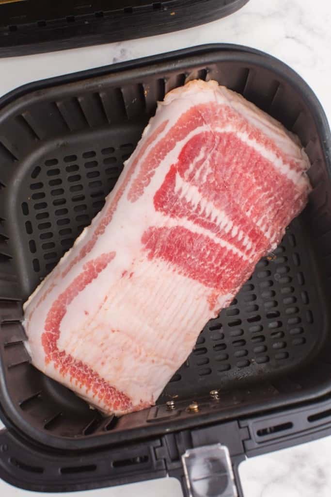 raw bacon in an air fryer basket