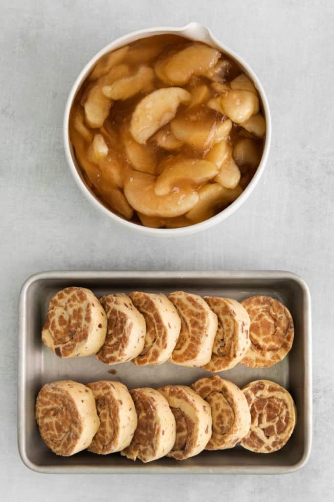 raw cinnamon rolls and a bowl of apple pie filing