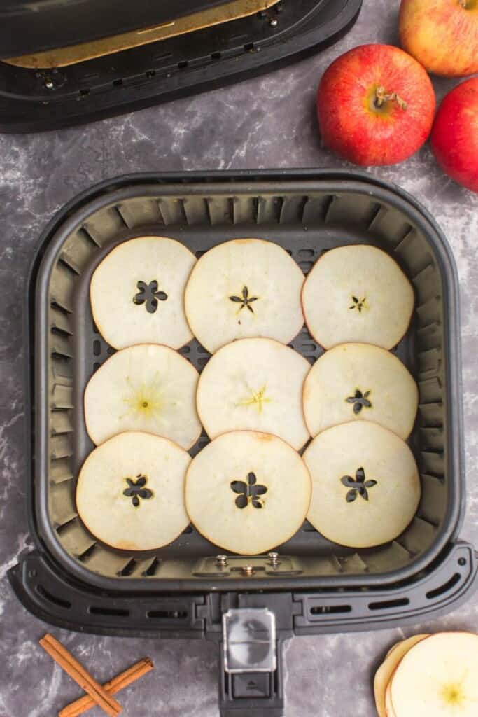 slices of apples in air fryer basket