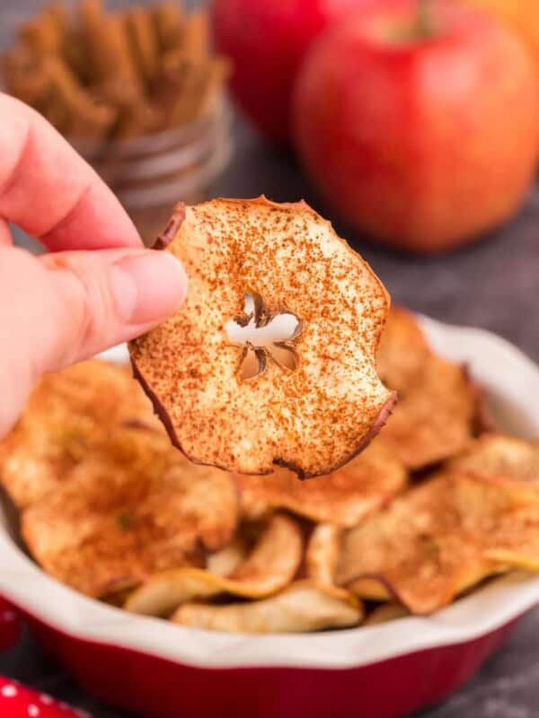 hand picking up an air fryer apple chips