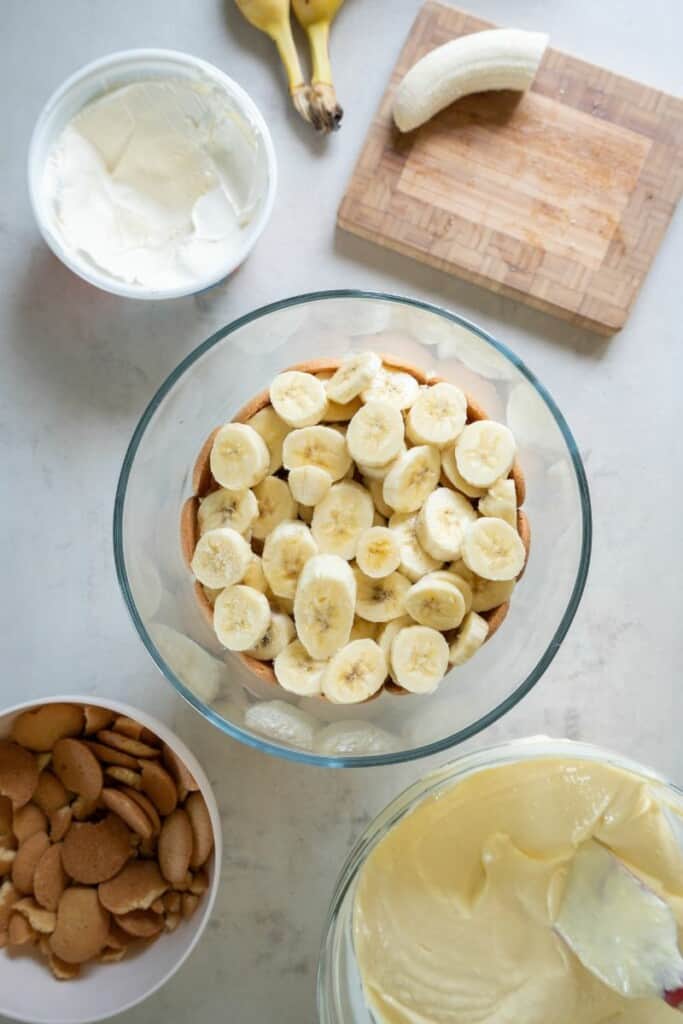 layering bananas, cookies and pudding