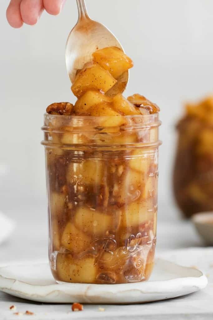 jar with a spoon in it with cinnamon roll apple pie filling