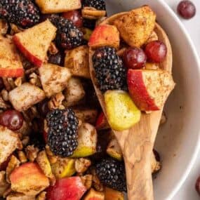 wooden spoon holding fall fruit salad