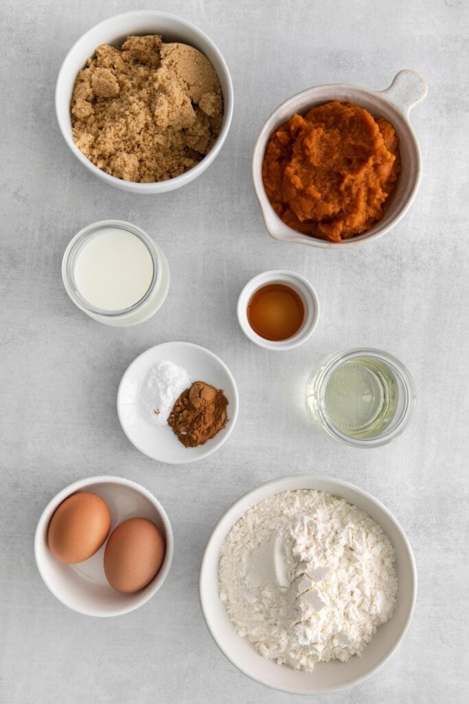 Ingredients needed to make my pumpkin bread recipe: pumpkin puree, eggs, milk, vegetable oil, vanilla, brown sugar, flour, pumpkin pie spice, and baking soda.