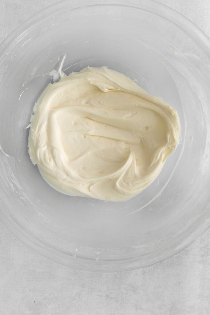 Cream cheese frosting in a bowl ready to be spread on the pumpkin bread.