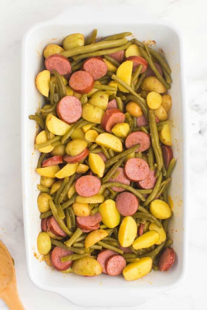 mixed potatoes, sausage and green beans in a casserole dish