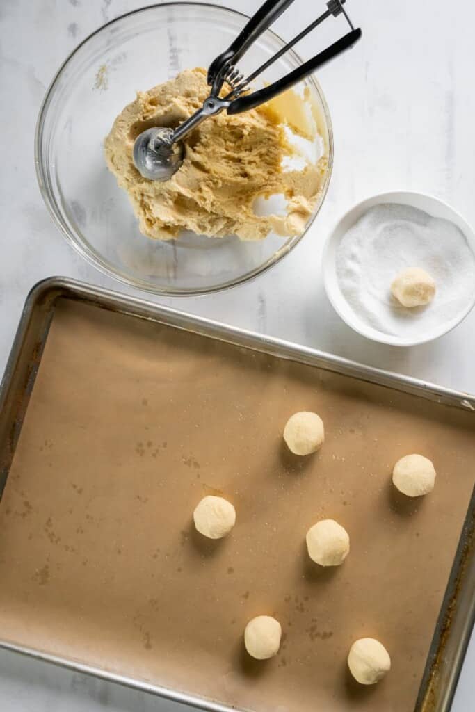 adding cookie dough to baking sheet