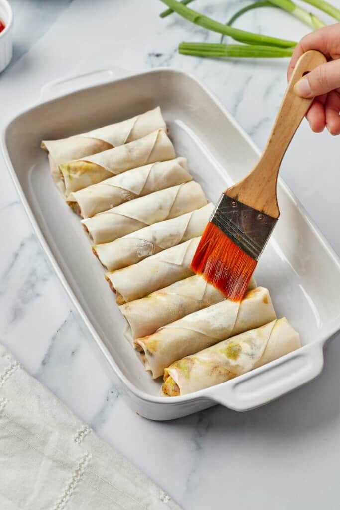 Brushing spring rolls with oil