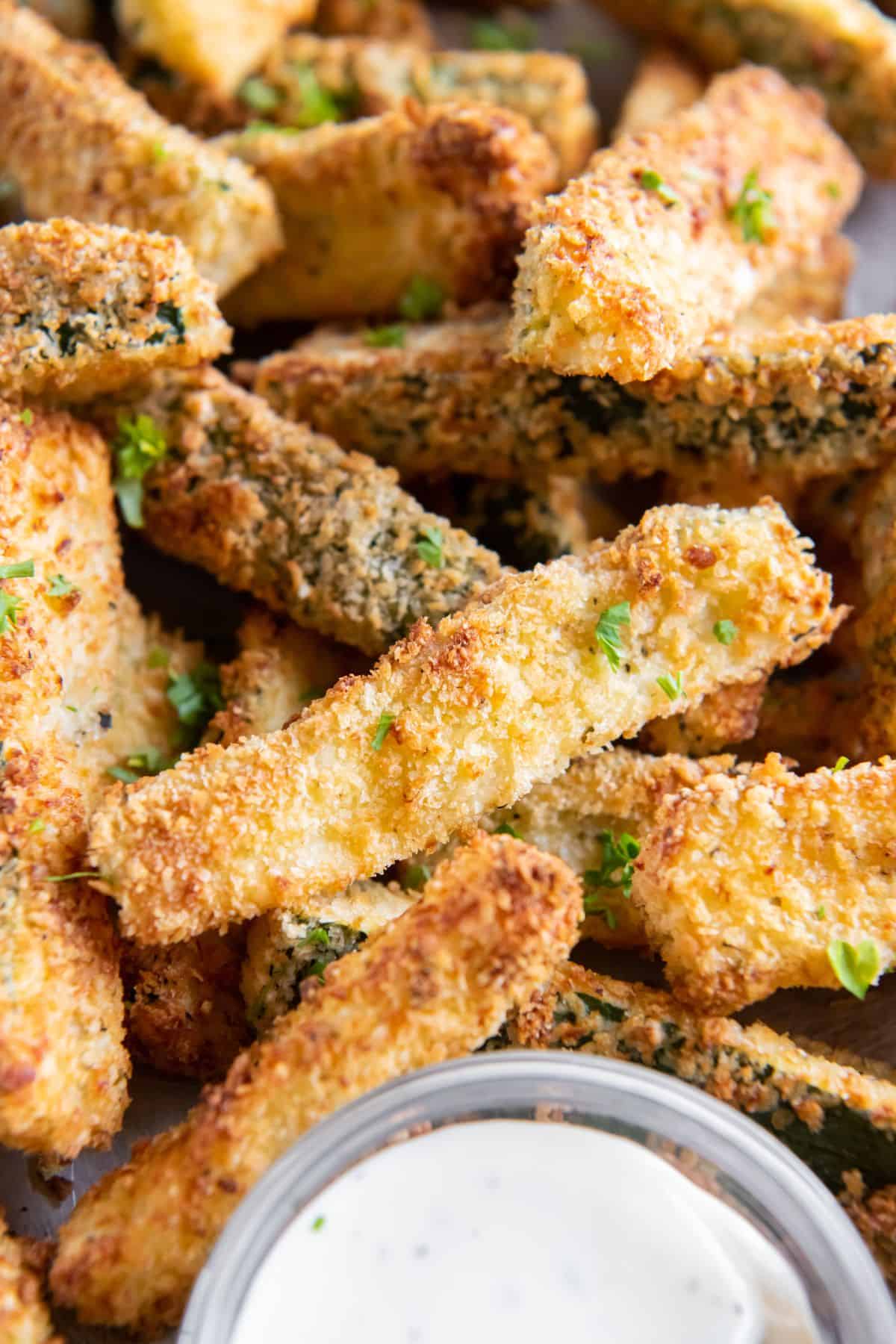 Close up of the air fried zucchini to show the golden brown breading.
