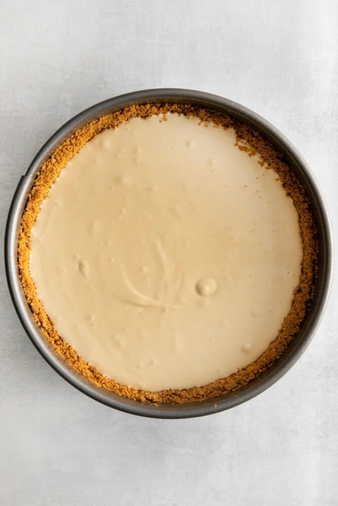 The graham cracker crust filled with caramel cheesecake to make the apple crumble cheesecake.