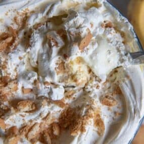 The top of the banana pudding recipe with cool whip to show crumbles of Nilla wafers and the super creamy texture.