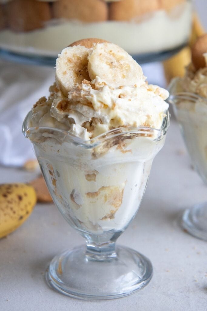 Close up side view of banana pudding with sour cream in an individual serving dish.
