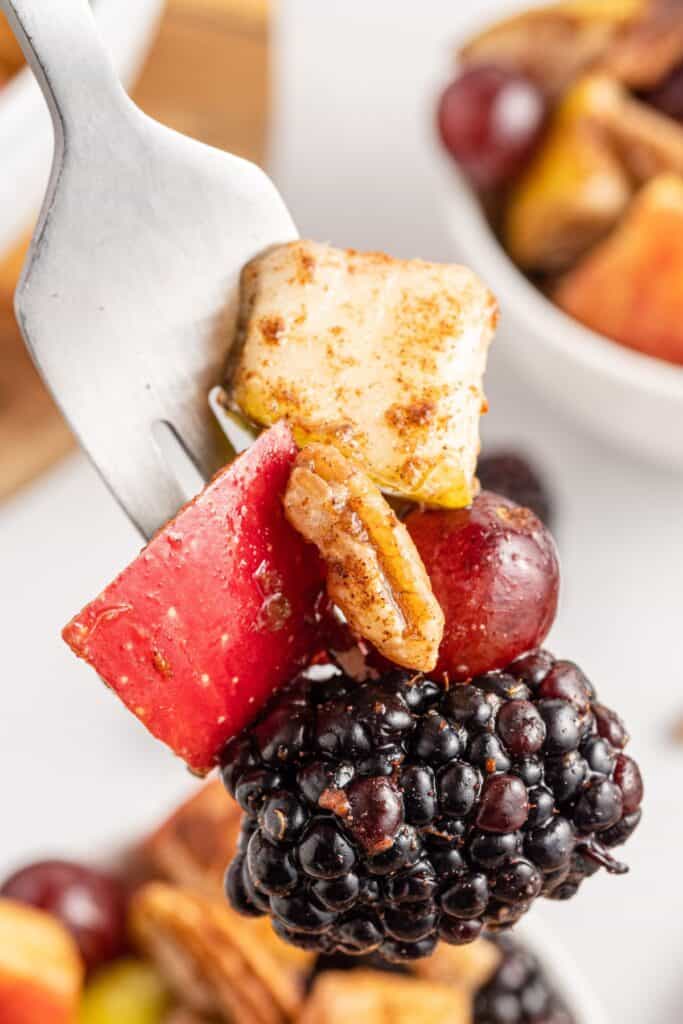 Close up of the fall fruit salad recipe on a fork about to be eaten.