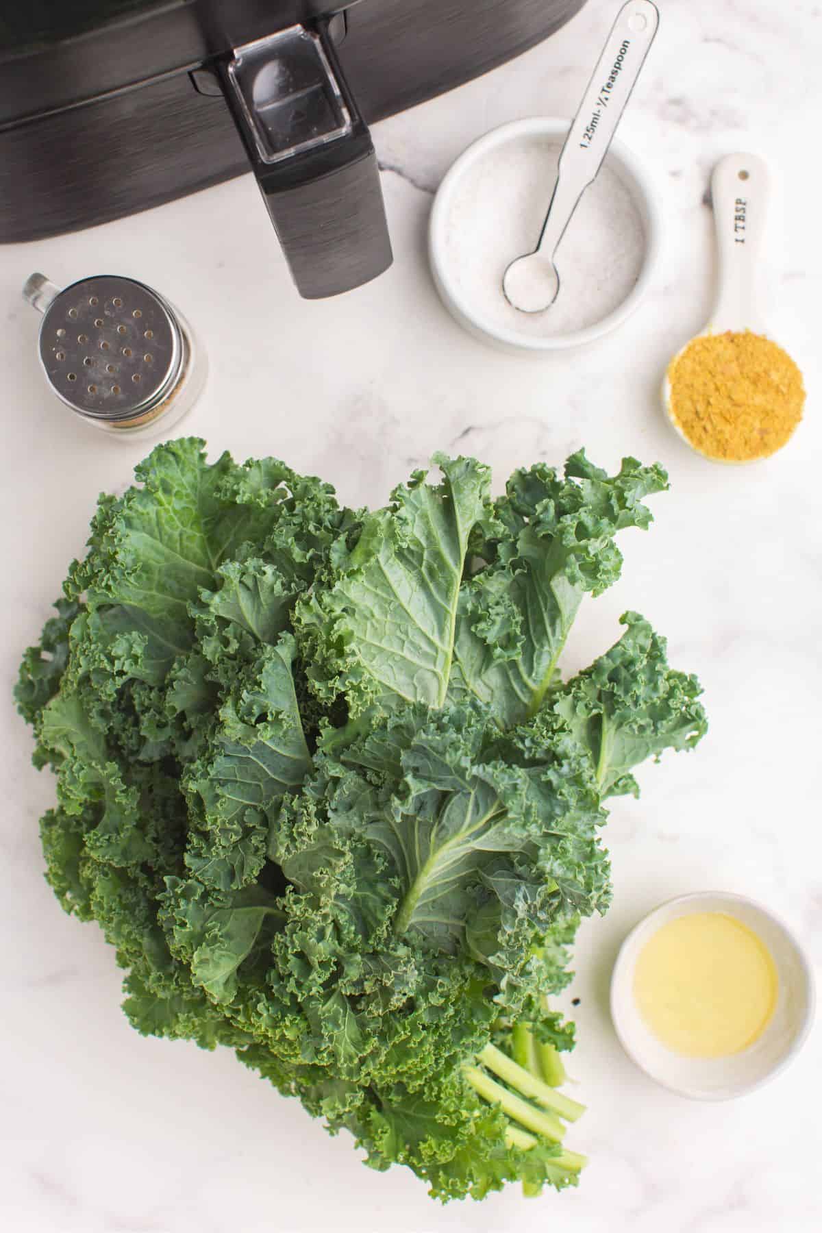 Ingredients needed to make kale chips in the air fryer: kale, oil, nutritional yeast, salt, and pepper.