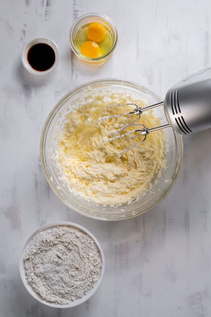 Butter and sugar creamed together in a mixing bowl to make homemade sugar cookies.