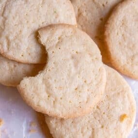 Sugar cookie recipe without baking soda on the counter with a bite taken out of one of them.