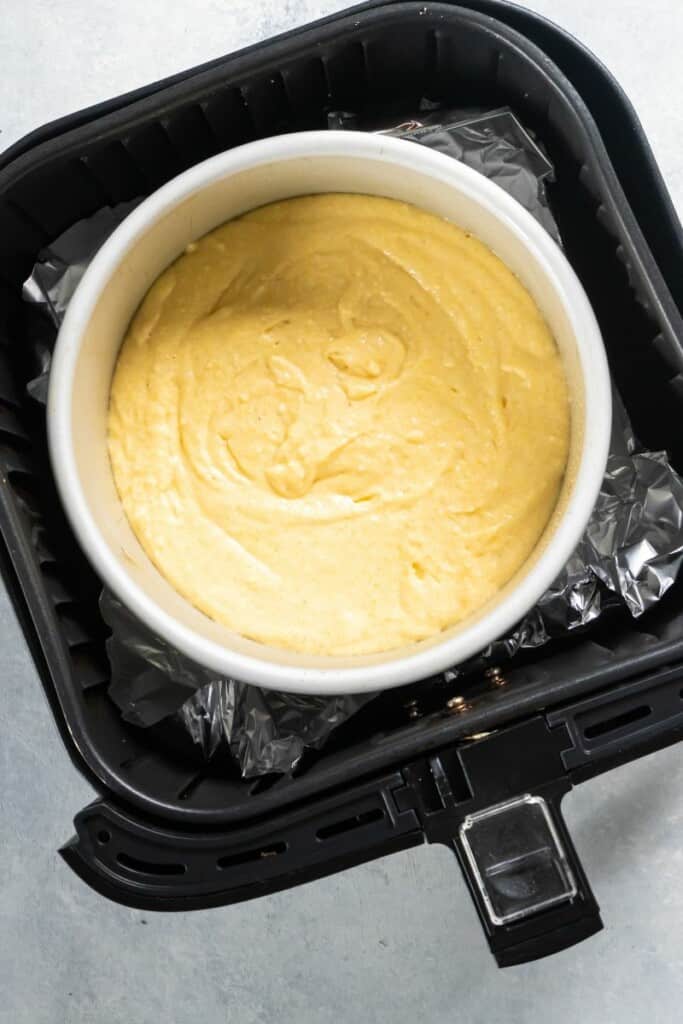 cornbread batter in a pan in an air fryer basket