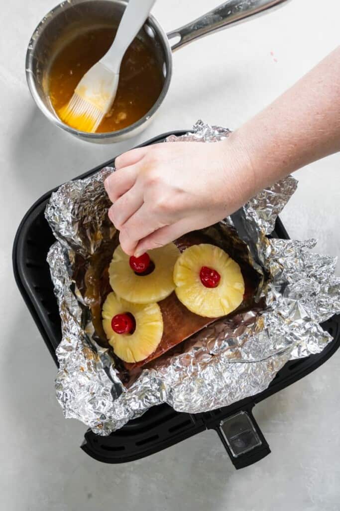 adding pineapple and cherries to ham