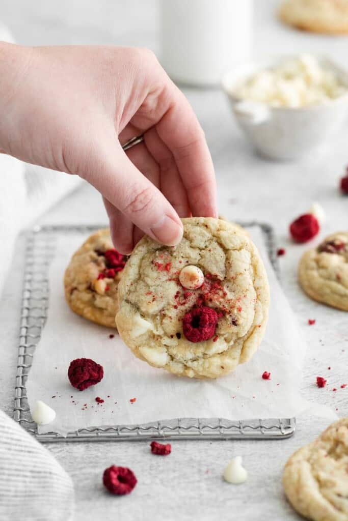 hand holding up a white chocolate raspberry cookie