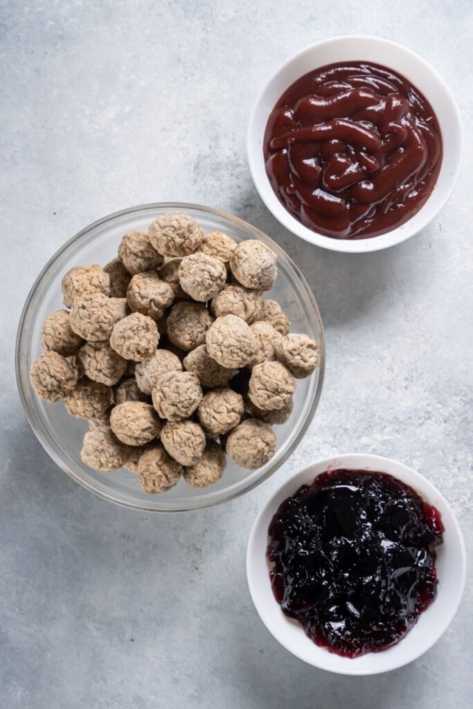 Ingredients needed to make crockpot meatballs: frozen meatballs, cranberry sauce, and grape jelly.