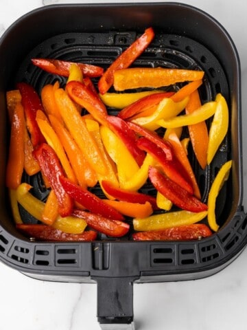 raw bell peppers in an air fryer basket