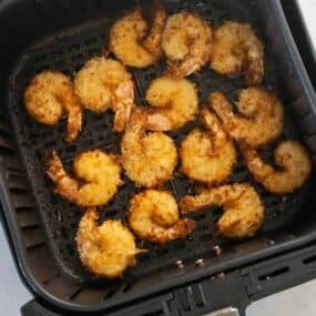 air fryer basket with cooked shrimp