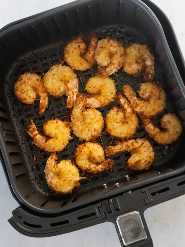 air fryer basket with cooked shrimp